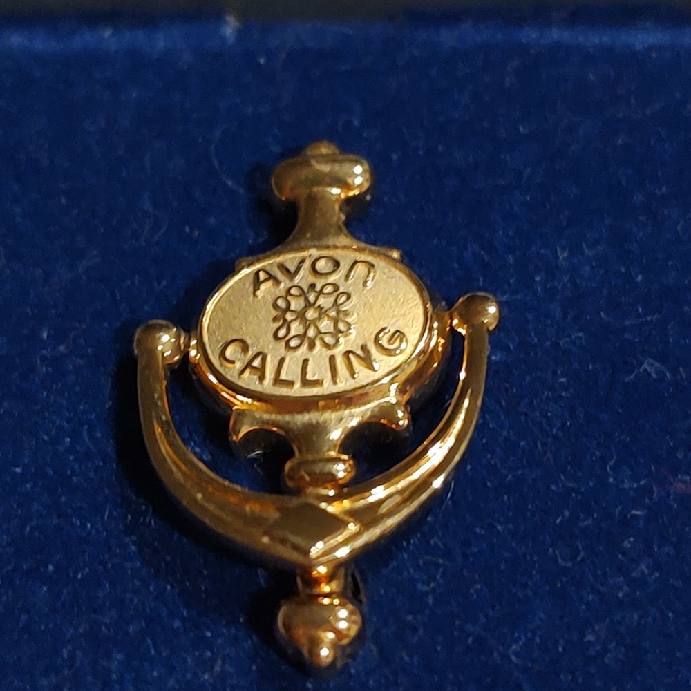This vintage Avon brooch features an asymmetrical door knocker design awarded